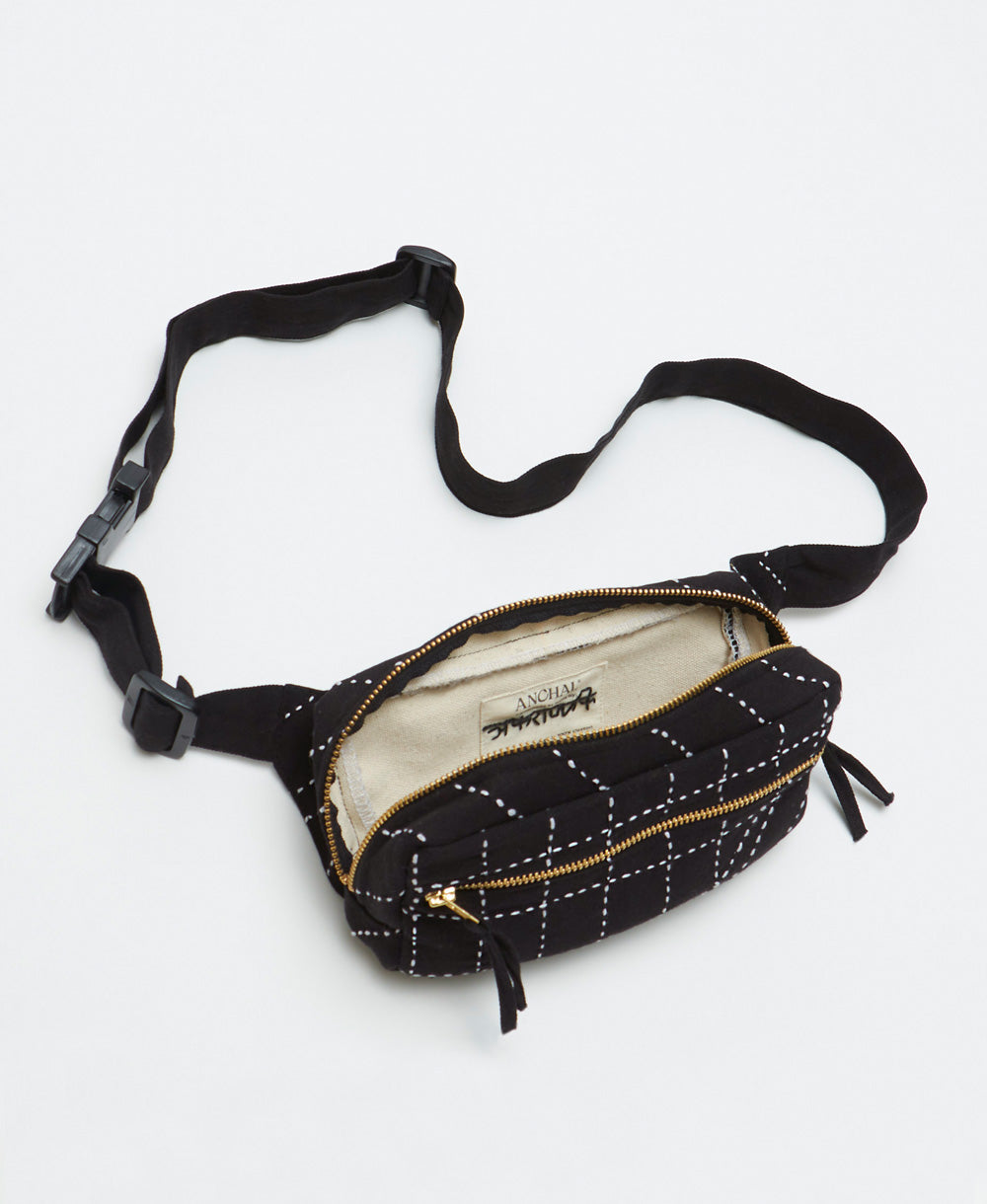 Black waist bag with white stitching on a light gray background