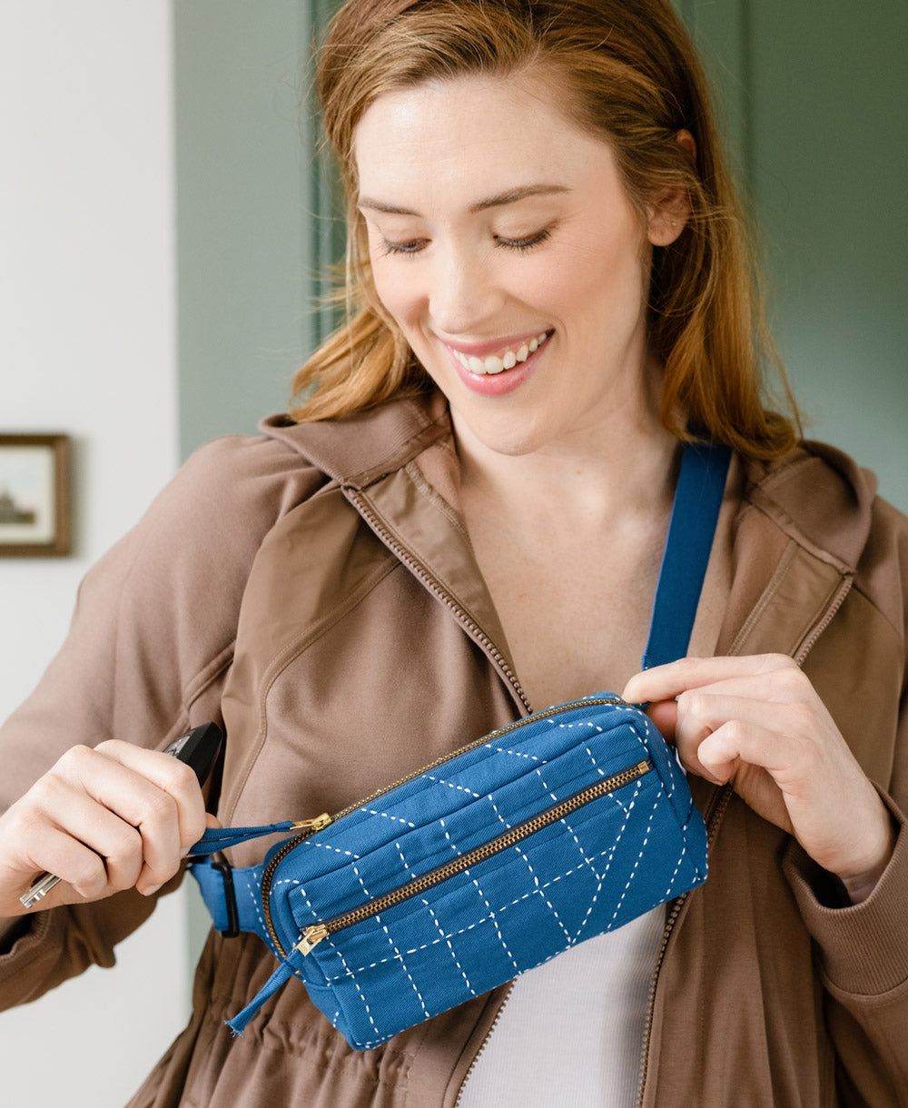 Woman holding a blue quilted handbag indoors