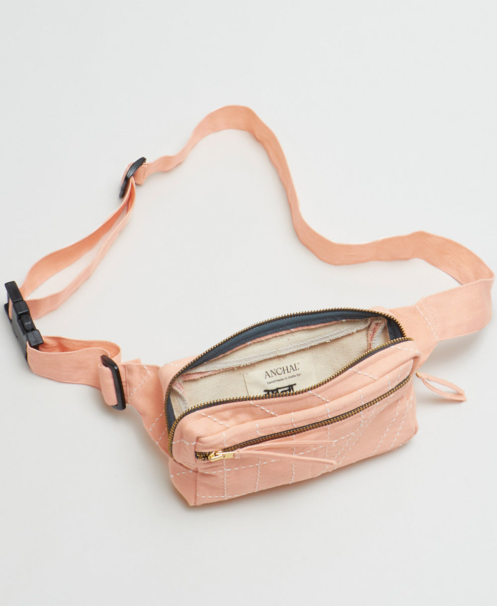 Pink fanny pack with a visible brand name on a light gray background