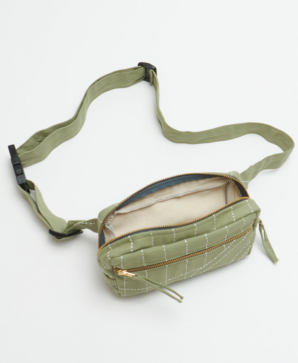 sage green fanny pack with white embroidery and an adjustable strap