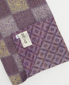 kantha quilt throw with a tag featuring the hand-stitched signature of the maker