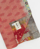 kantha quilt throw with a tag featuring the hand-stitched signature of the maker