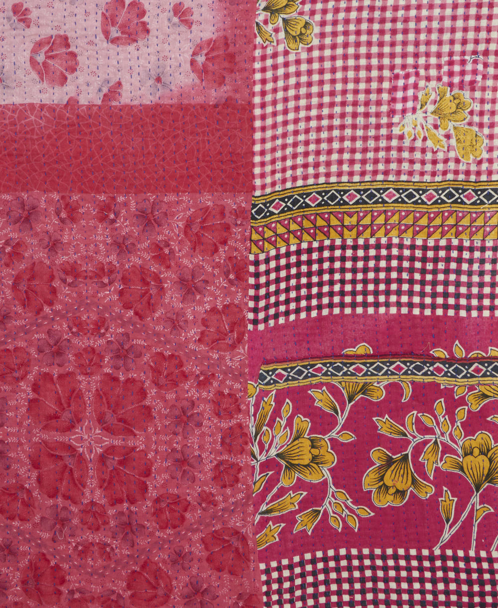 kantha quilt throw with a tag featuring the hand-stitched signature of the maker