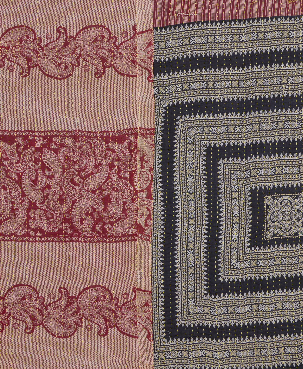 kantha quilt throw with a tag featuring the hand-stitched signature of the maker