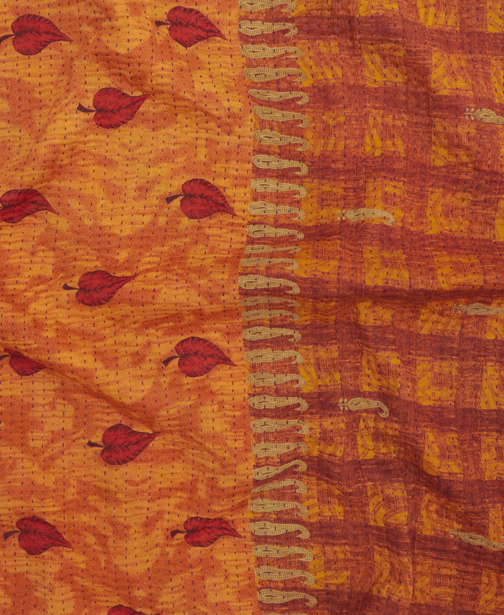 kantha quilt throw with a tag featuring the hand-stitched signature of the maker