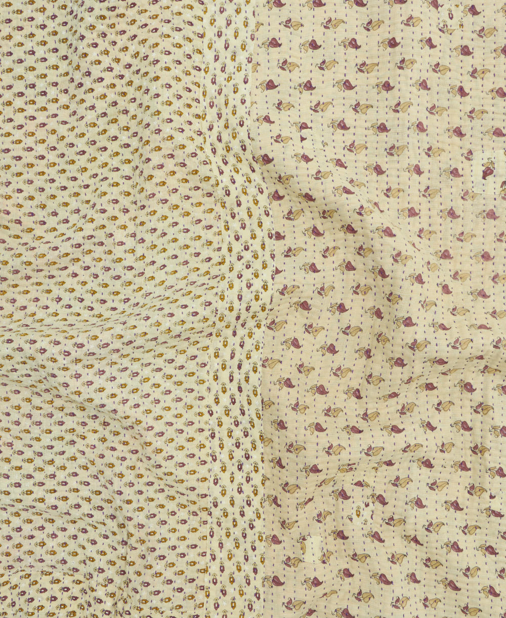 kantha quilt throw with a tag featuring the hand-stitched signature of the maker