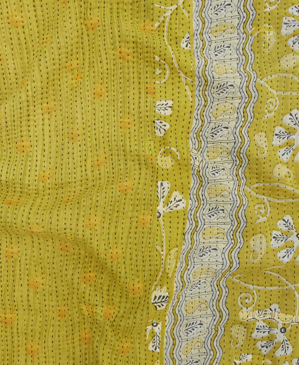 kantha quilt throw with a tag featuring the hand-stitched signature of the maker