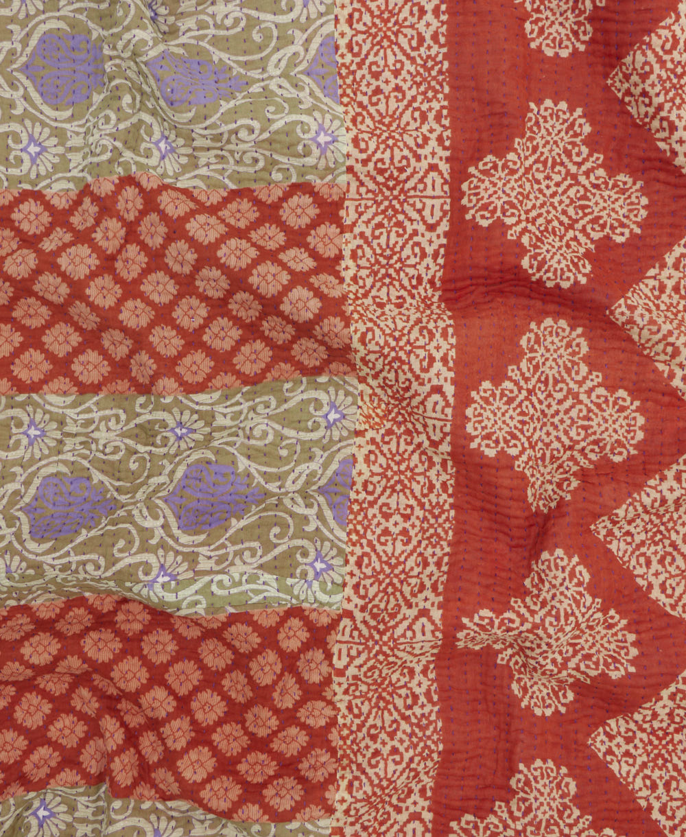 kantha quilt throw with a tag featuring the hand-stitched signature of the maker