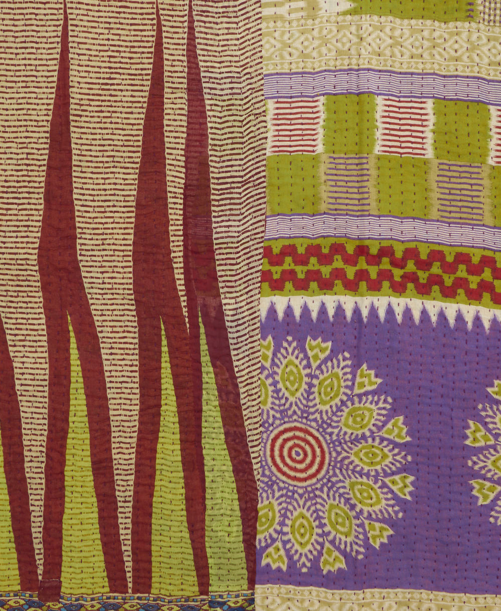 kantha quilt throw with a tag featuring the hand-stitched signature of the maker