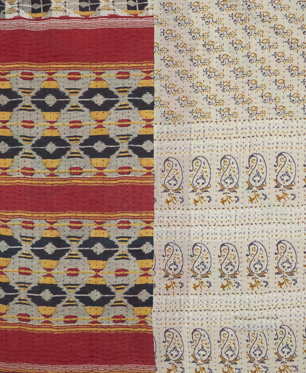kantha quilt throw with a tag featuring the hand-stitched signature of the maker