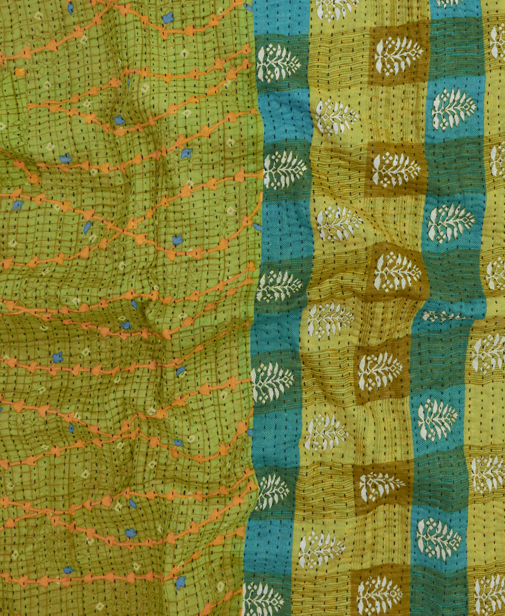 kantha quilt throw with a tag featuring the hand-stitched signature of the maker