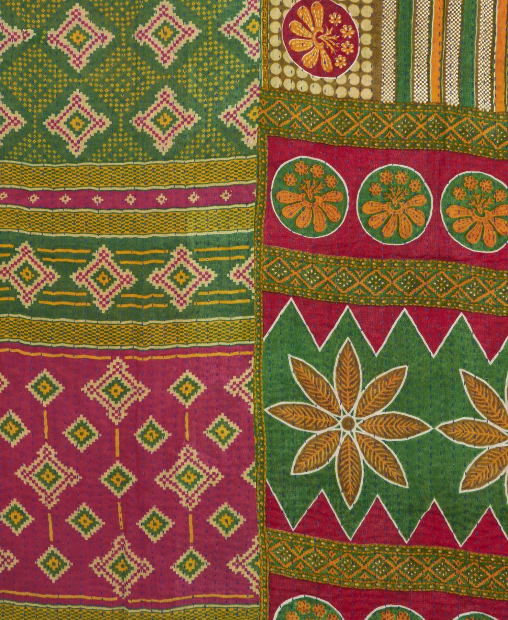 kantha quilt throw with a tag featuring the hand-stitched signature of the maker