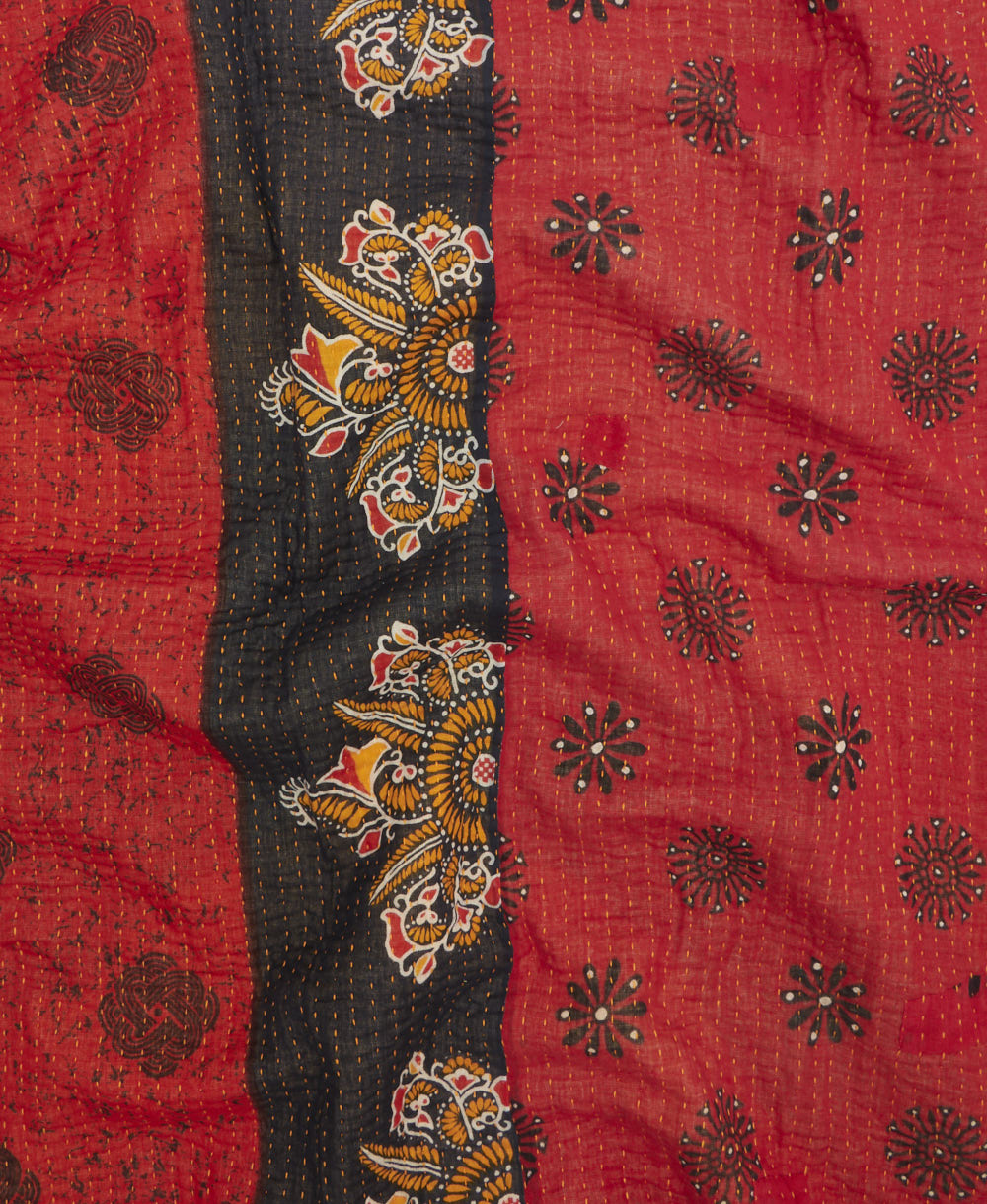 kantha quilt throw with a tag featuring the hand-stitched signature of the maker