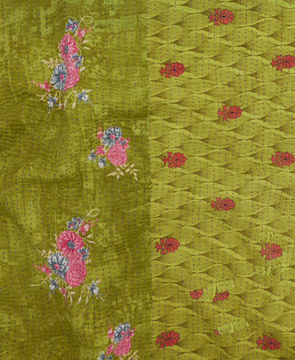 kantha quilt throw with a tag featuring the hand-stitched signature of the maker