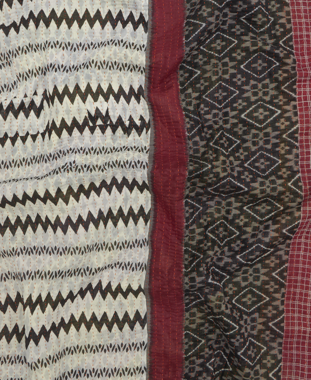 kantha quilt throw with a tag featuring the hand-stitched signature of the maker