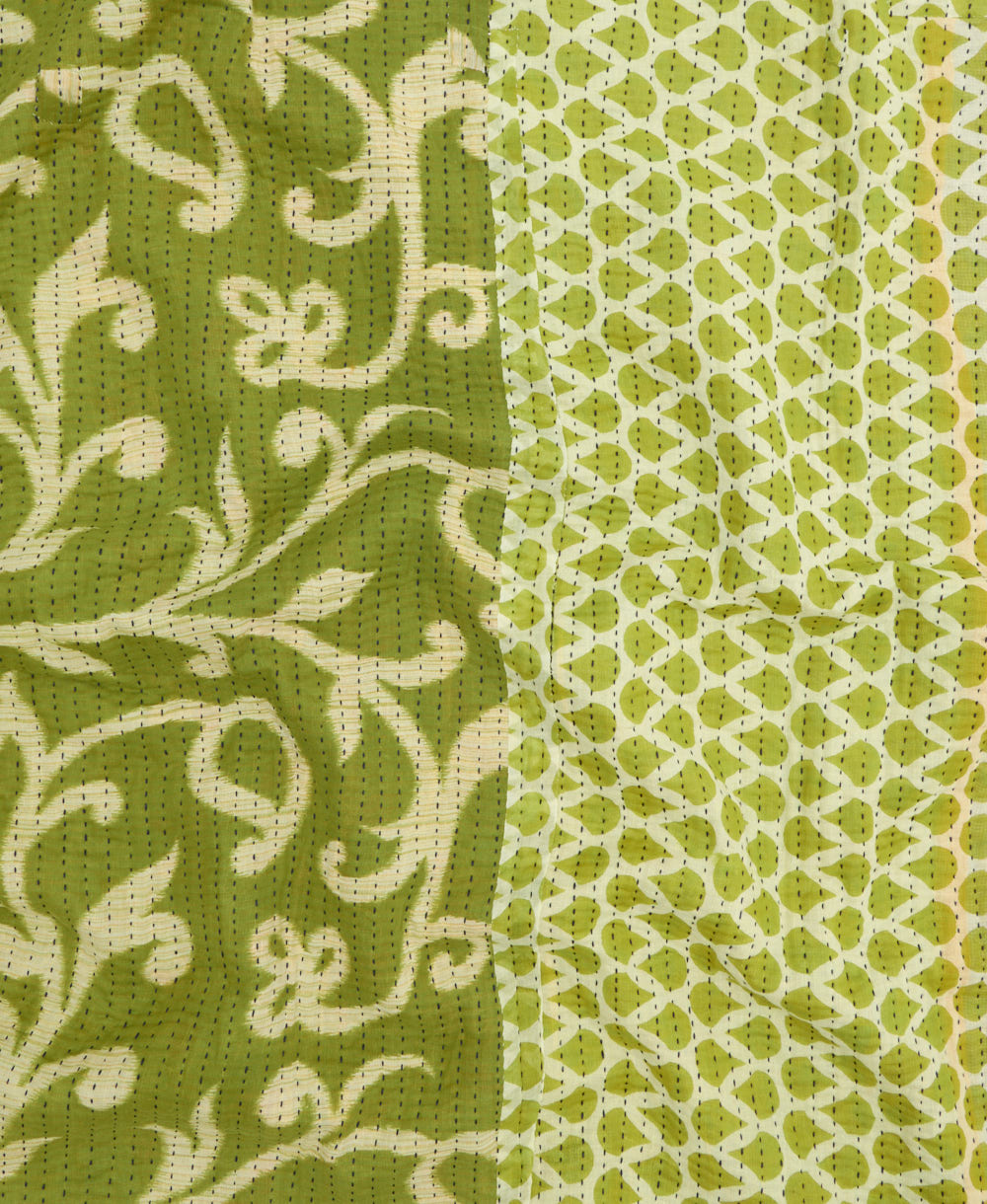 kantha quilt throw with a tag featuring the hand-stitched signature of the maker