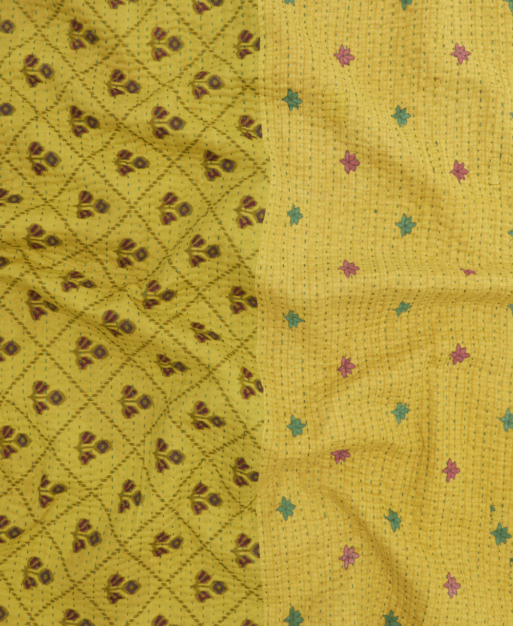 kantha quilt throw with a tag featuring the hand-stitched signature of the maker