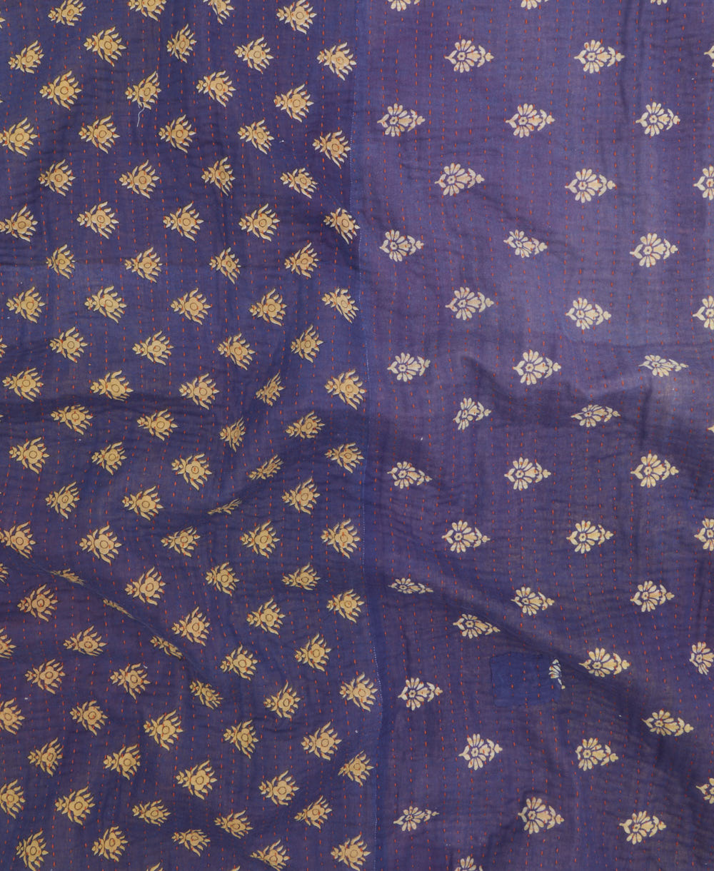 kantha quilt throw with a tag featuring the hand-stitched signature of the maker