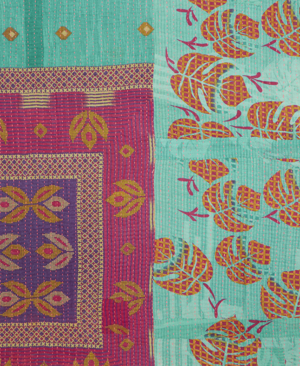 kantha quilt throw with a tag featuring the hand-stitched signature of the maker