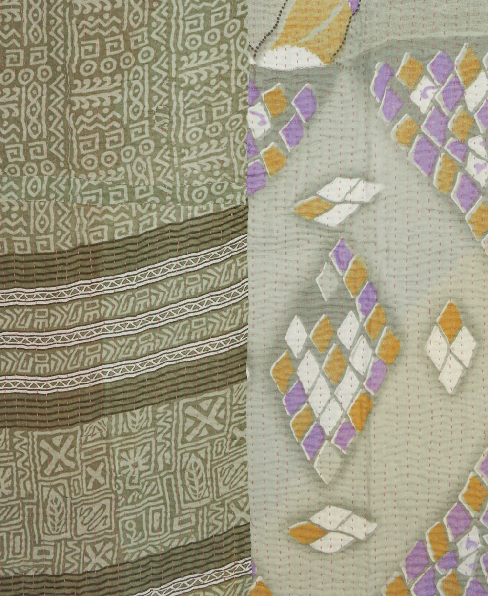 kantha quilt throw with a tag featuring the hand-stitched signature of the maker