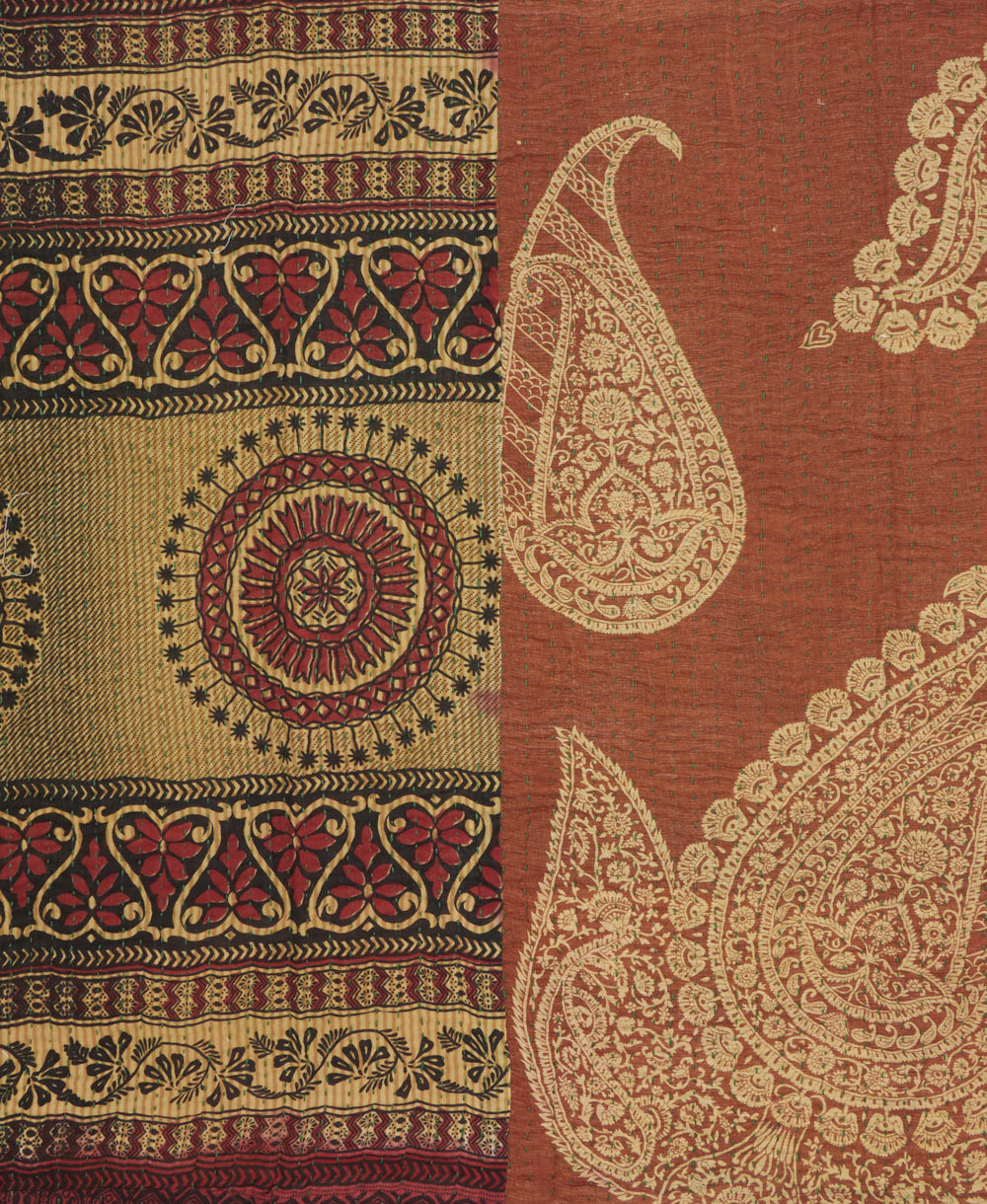 kantha quilt throw with a tag featuring the hand-stitched signature of the maker