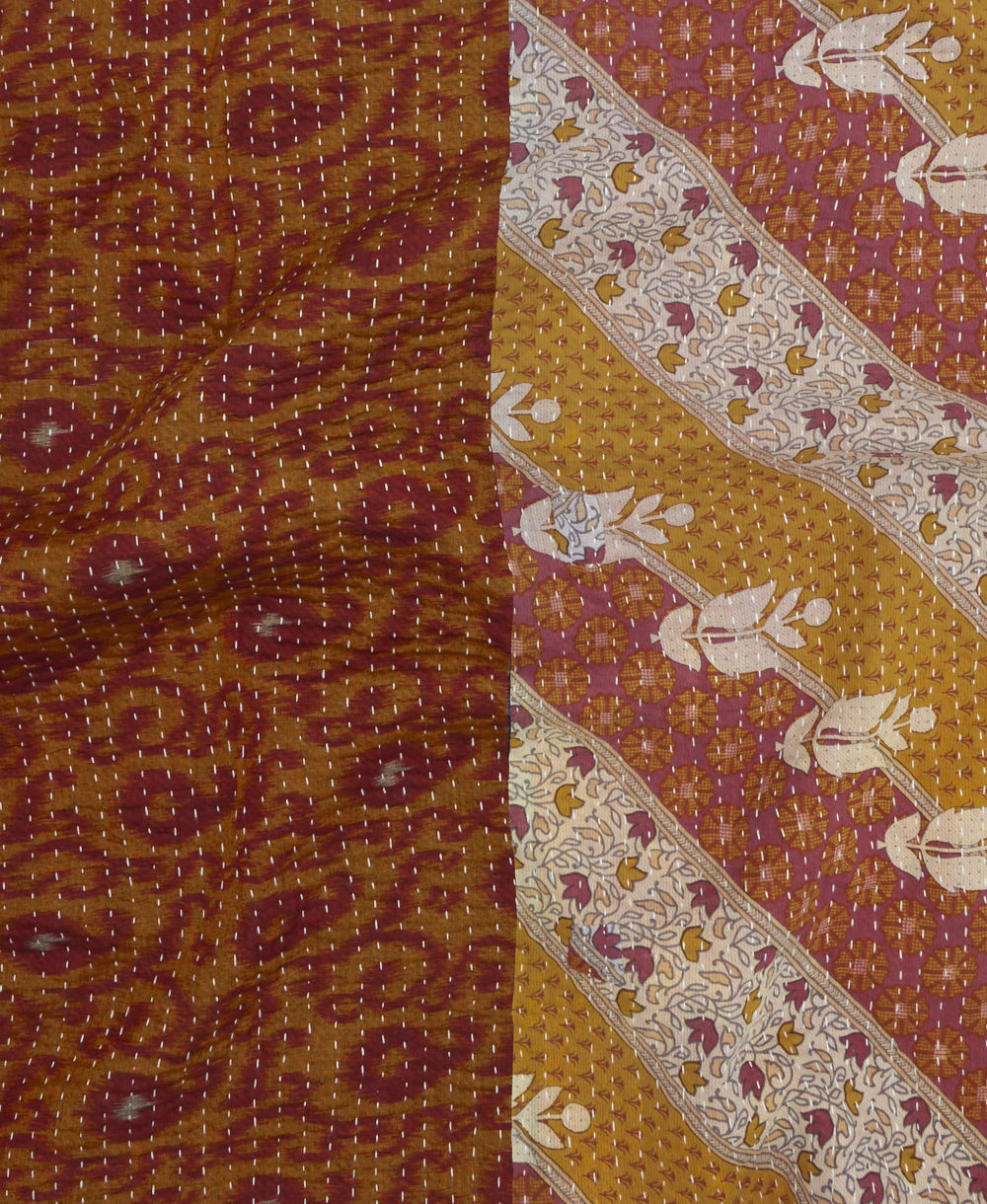 kantha quilt throw with a tag featuring the hand-stitched signature of the maker