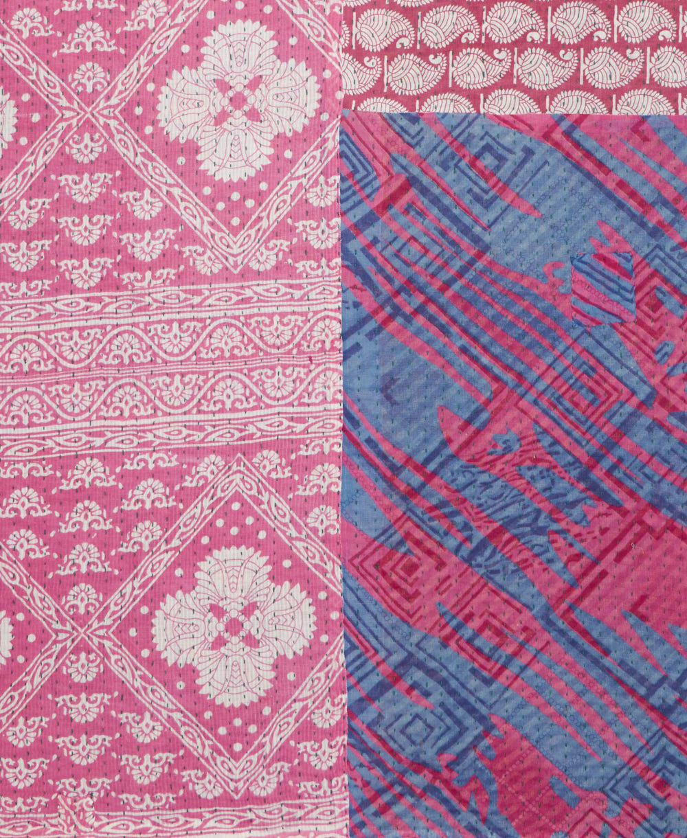 kantha quilt throw with a tag featuring the hand-stitched signature of the maker