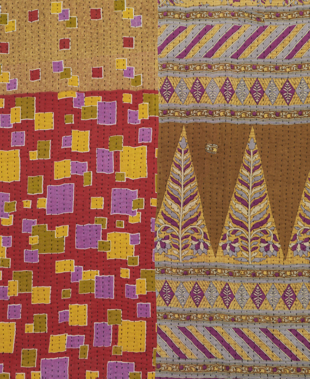 kantha quilt throw with a tag featuring the hand-stitched signature of the maker