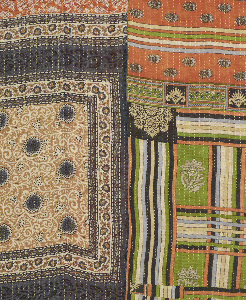 kantha quilt throw with a tag featuring the hand-stitched signature of the maker