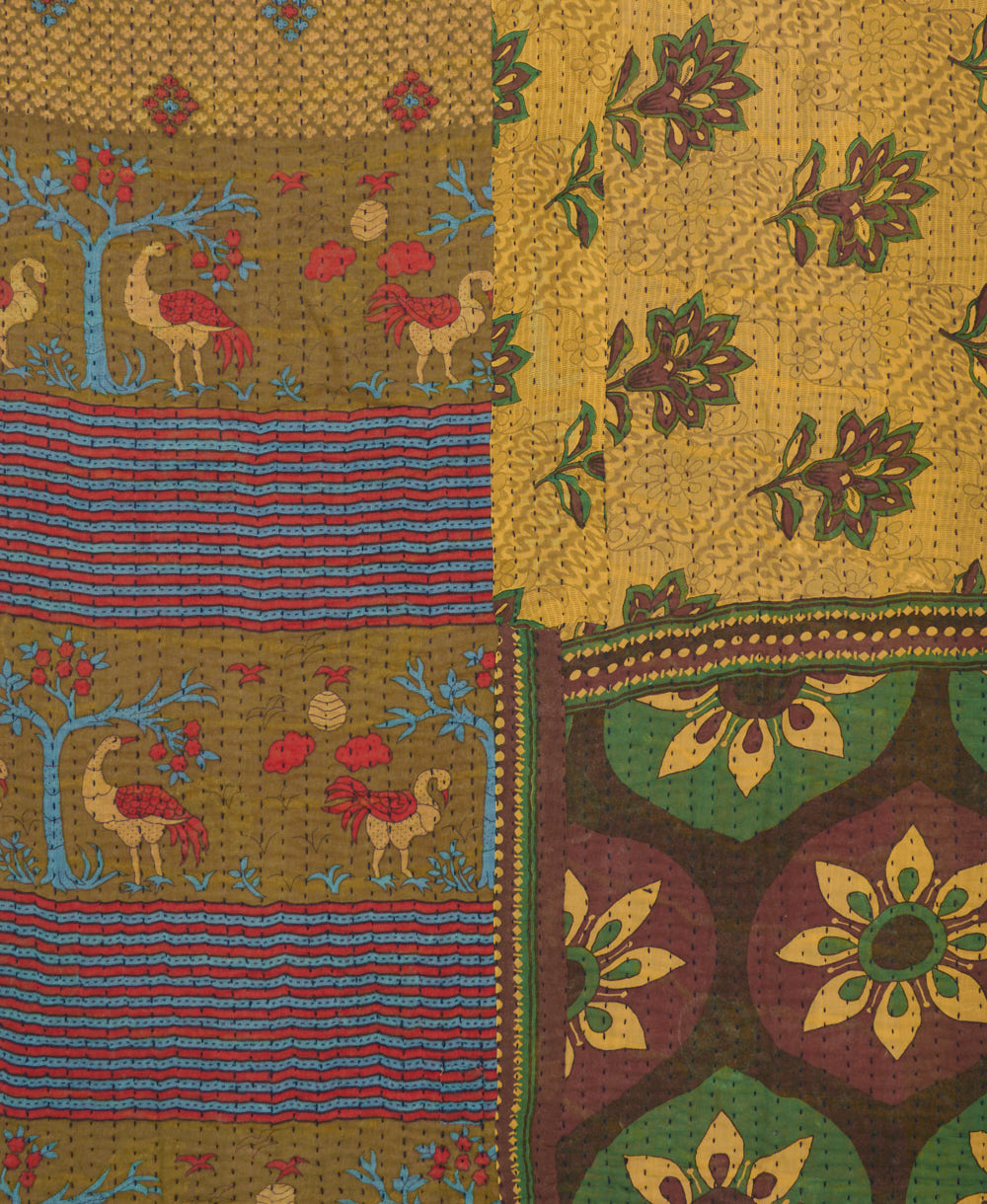 kantha quilt throw with a tag featuring the hand-stitched signature of the maker