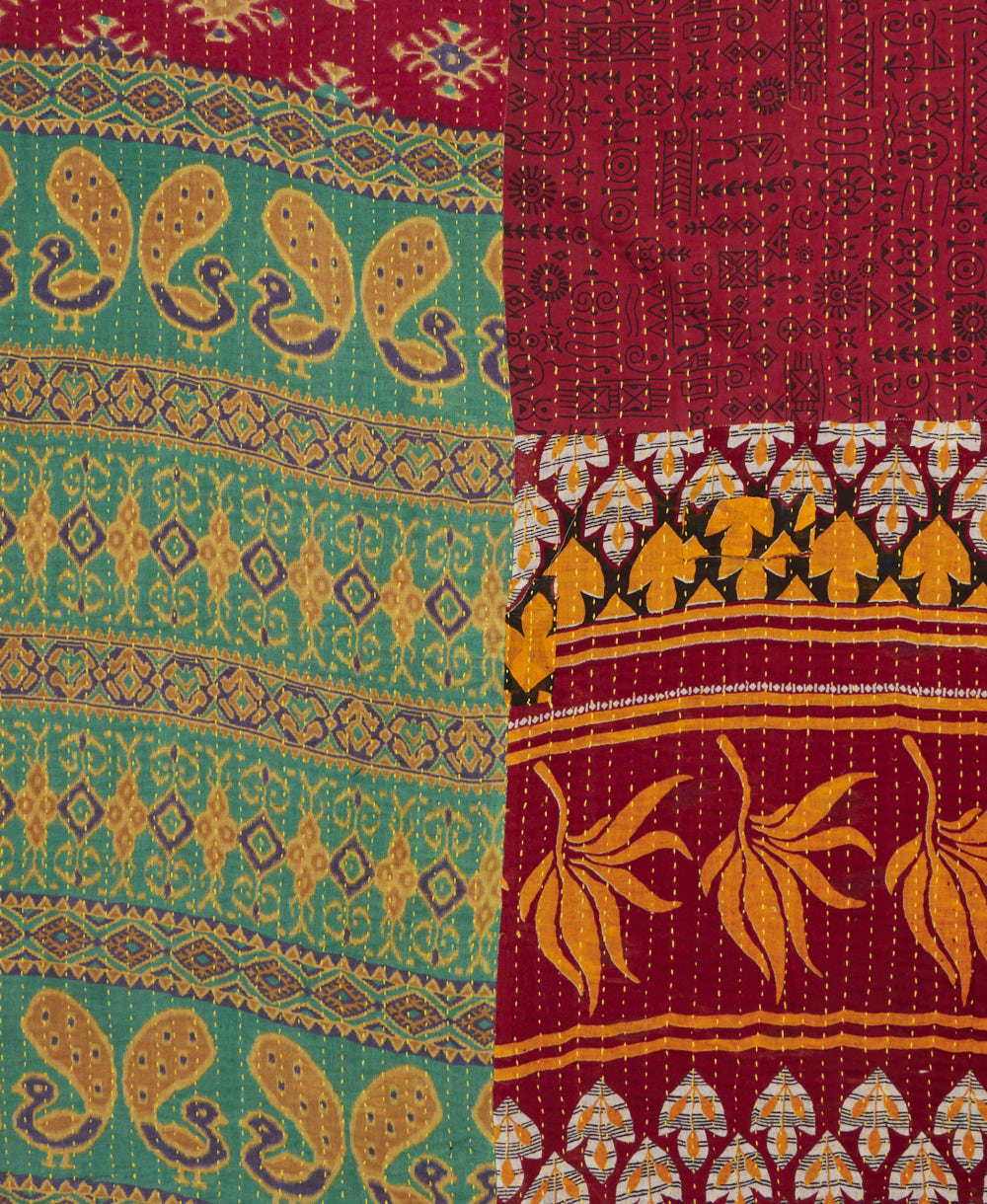 kantha quilt throw with a tag featuring the hand-stitched signature of the maker