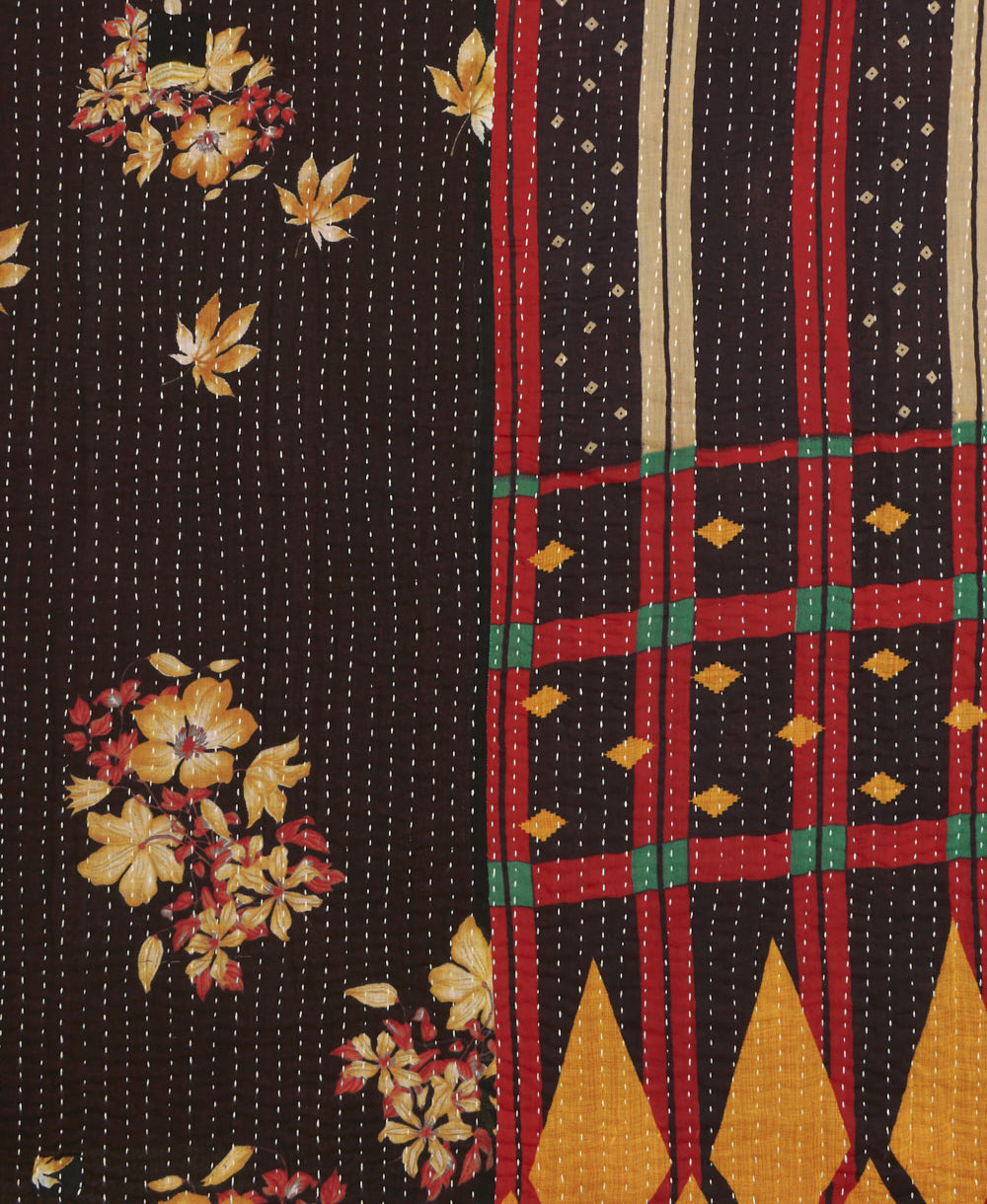 kantha quilt throw with a tag featuring the hand-stitched signature of the maker