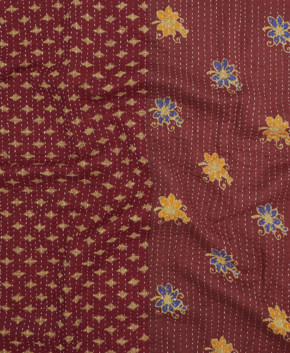 kantha quilt throw with a tag featuring the hand-stitched signature of the maker