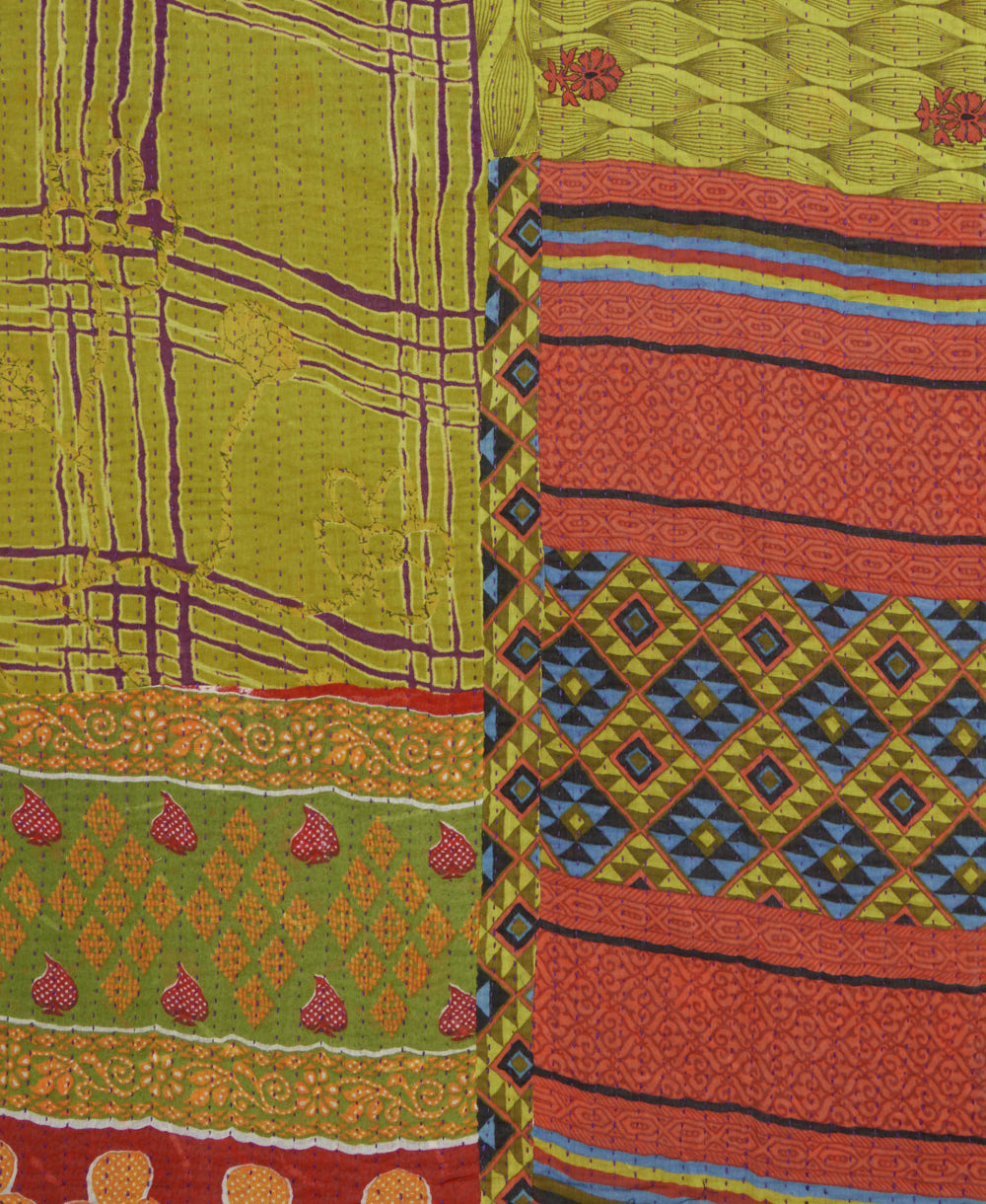 kantha quilt throw with a tag featuring the hand-stitched signature of the maker
