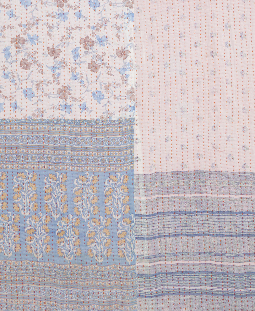 kantha quilt throw with a tag featuring the hand-stitched signature of the maker