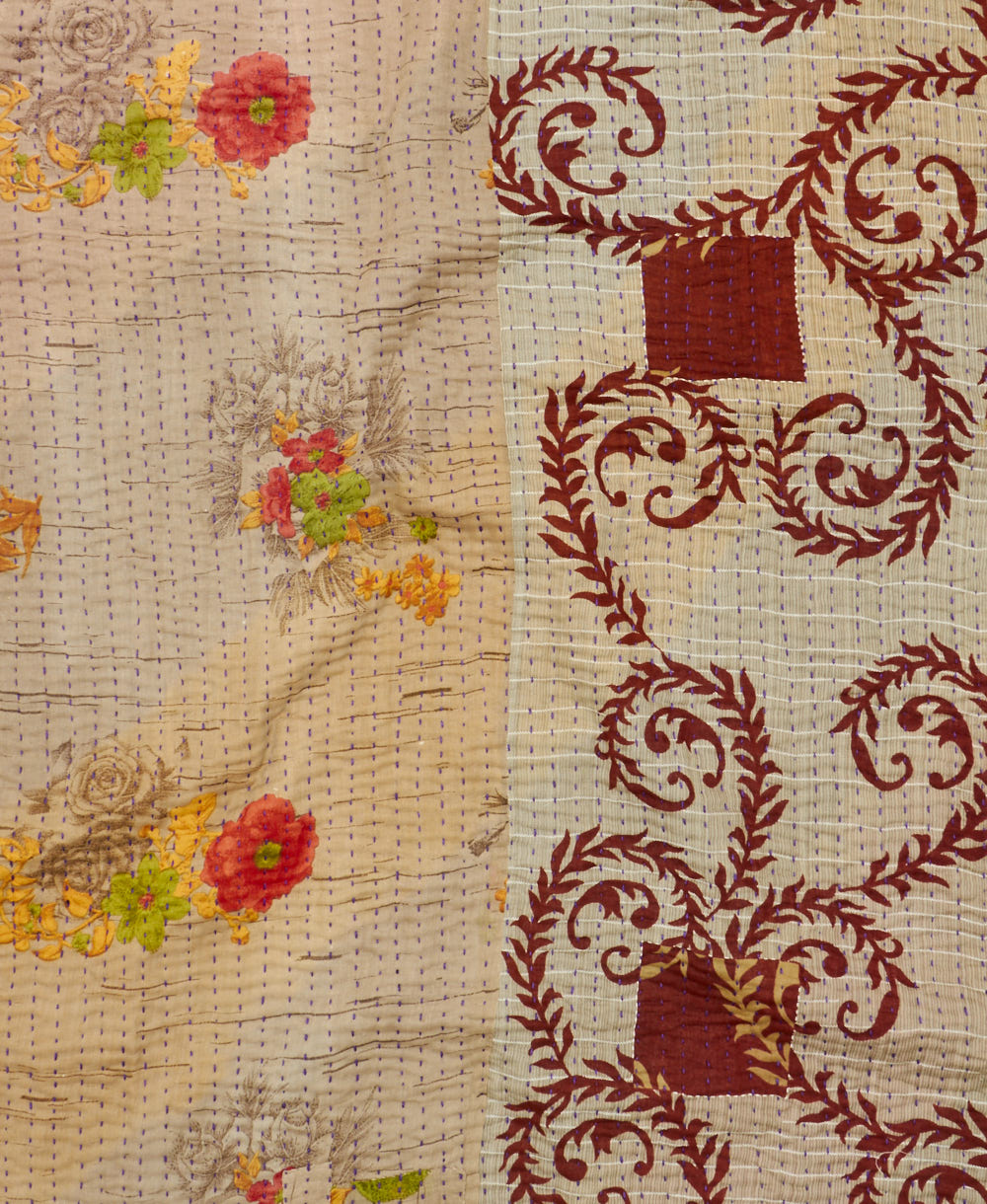 kantha quilt throw with a tag featuring the hand-stitched signature of the maker