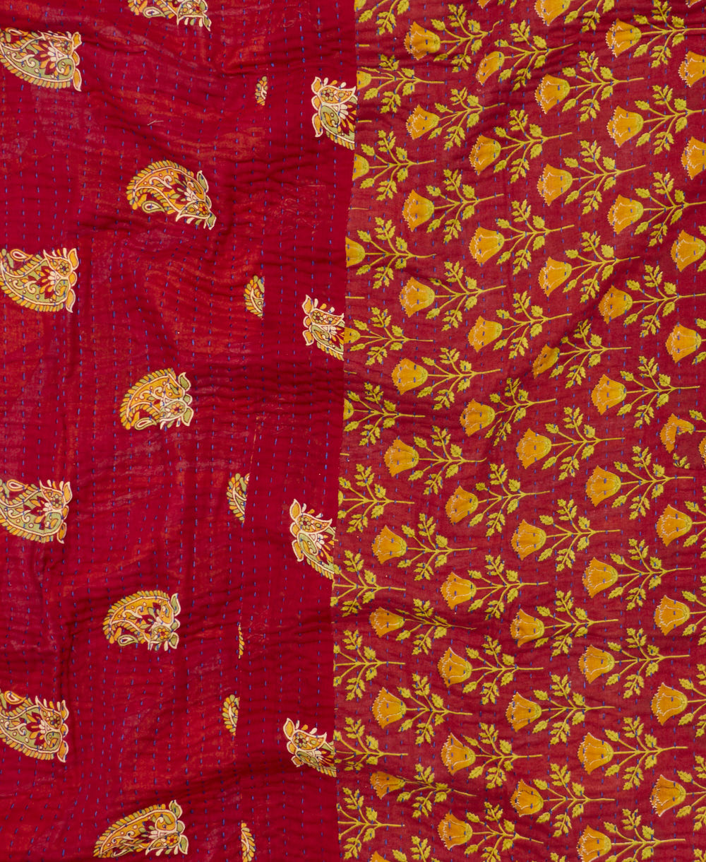 kantha quilt throw with a tag featuring the hand-stitched signature of the maker