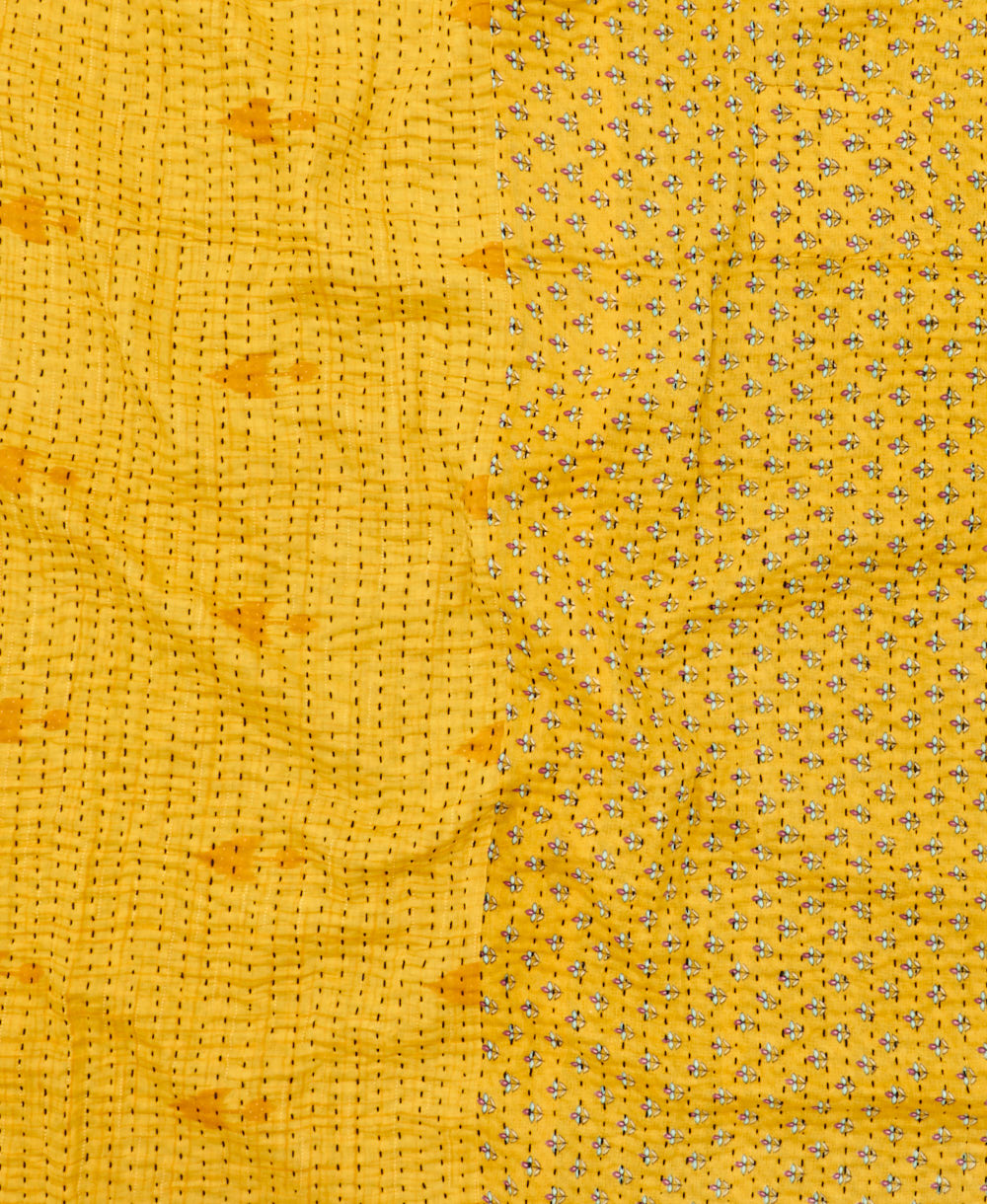 kantha quilt throw with a tag featuring the hand-stitched signature of the maker