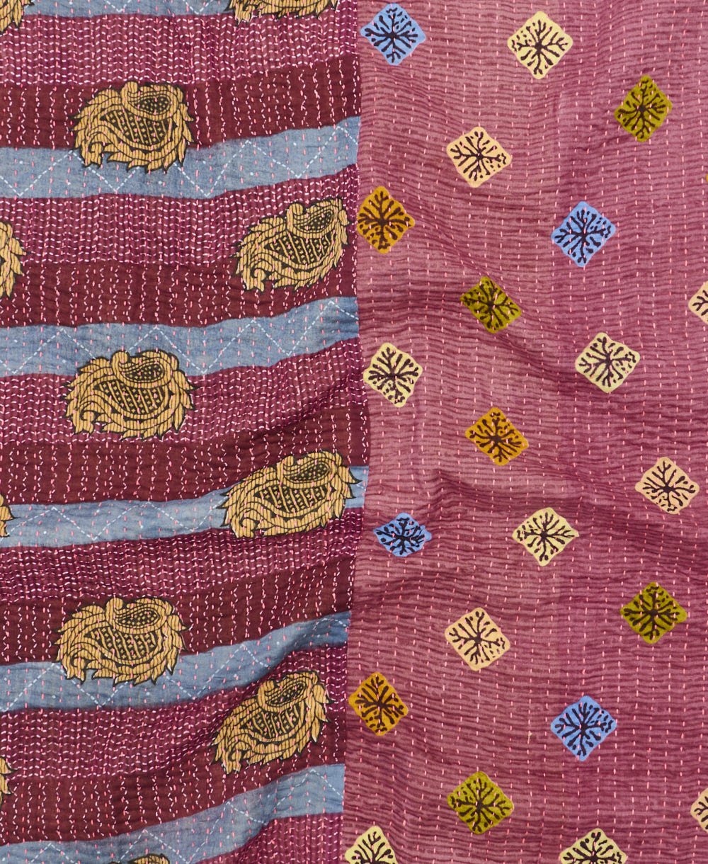 kantha quilt throw with a tag featuring the hand-stitched signature of the maker