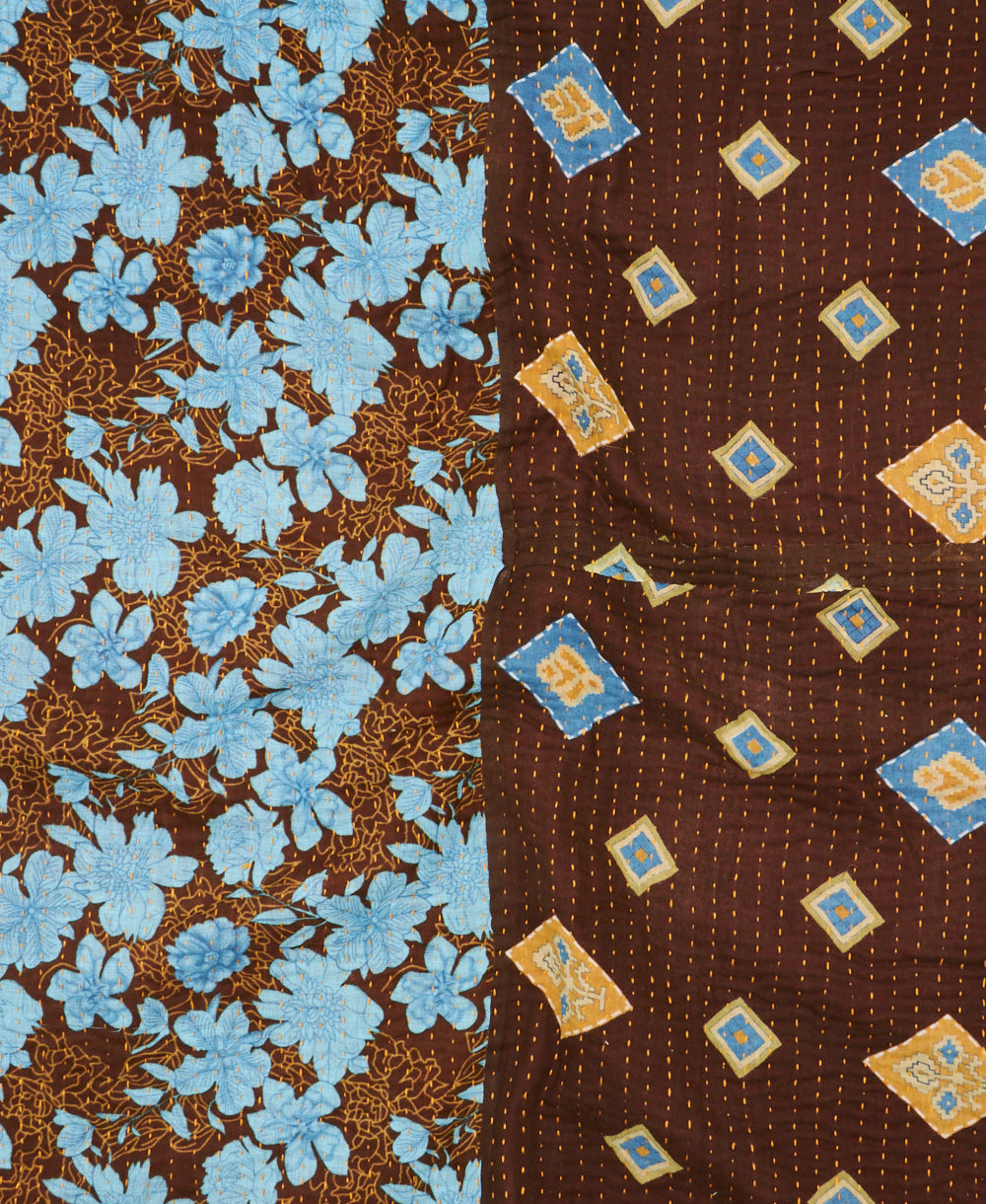 kantha quilt throw with a tag featuring the hand-stitched signature of the maker