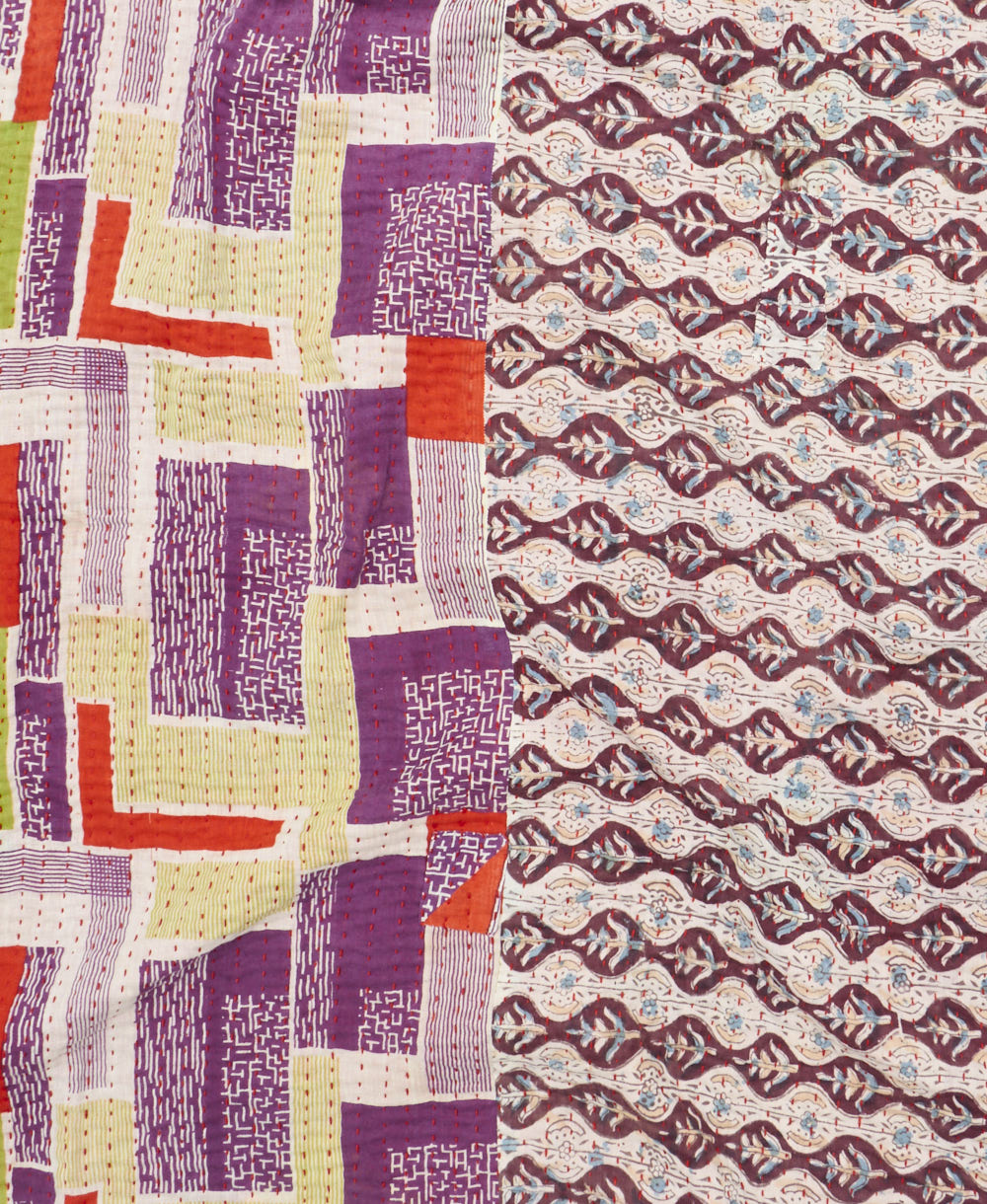 kantha quilt throw with a tag featuring the hand-stitched signature of the maker