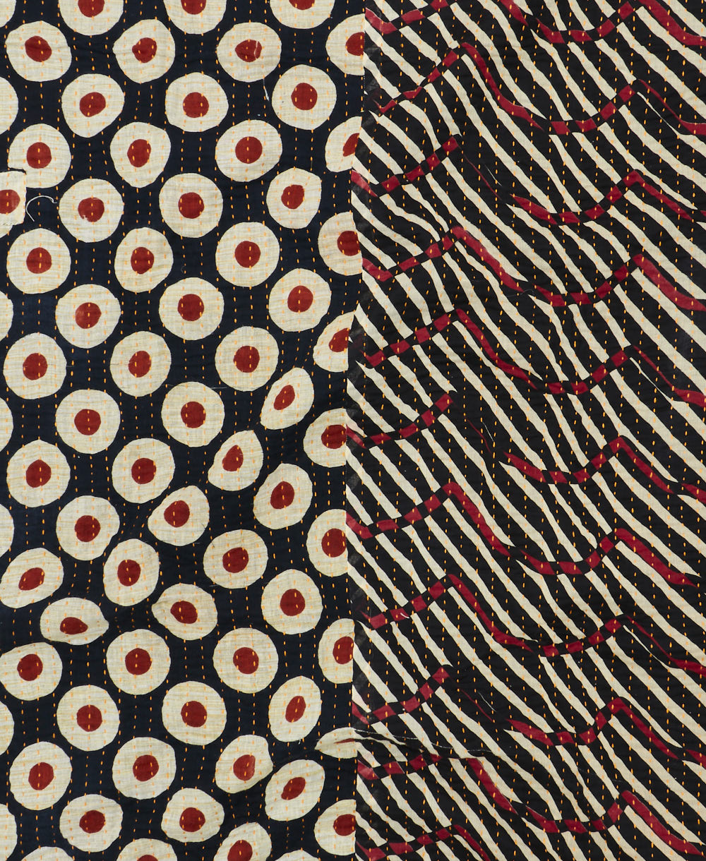 kantha quilt throw with a tag featuring the hand-stitched signature of the maker