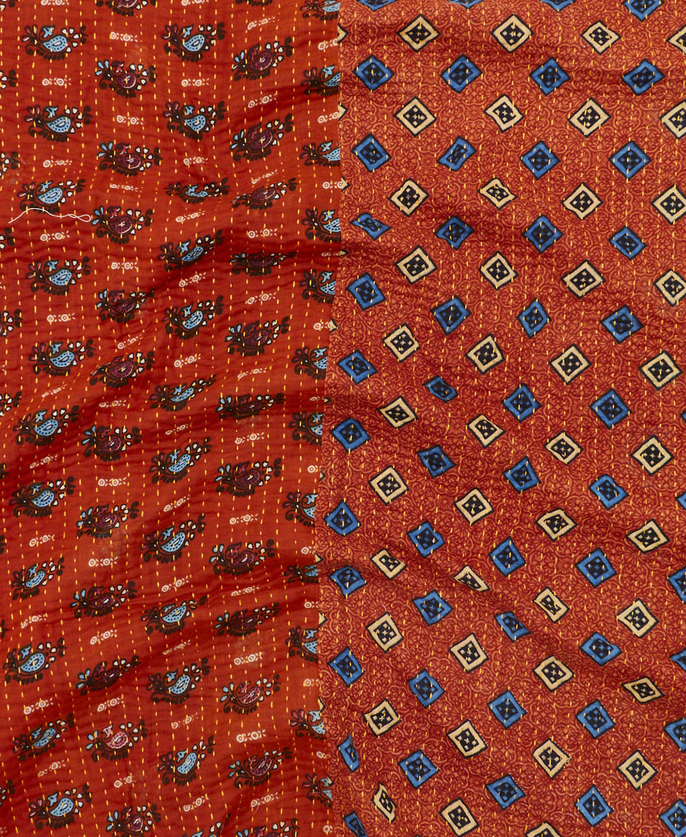 kantha quilt throw with a tag featuring the hand-stitched signature of the maker