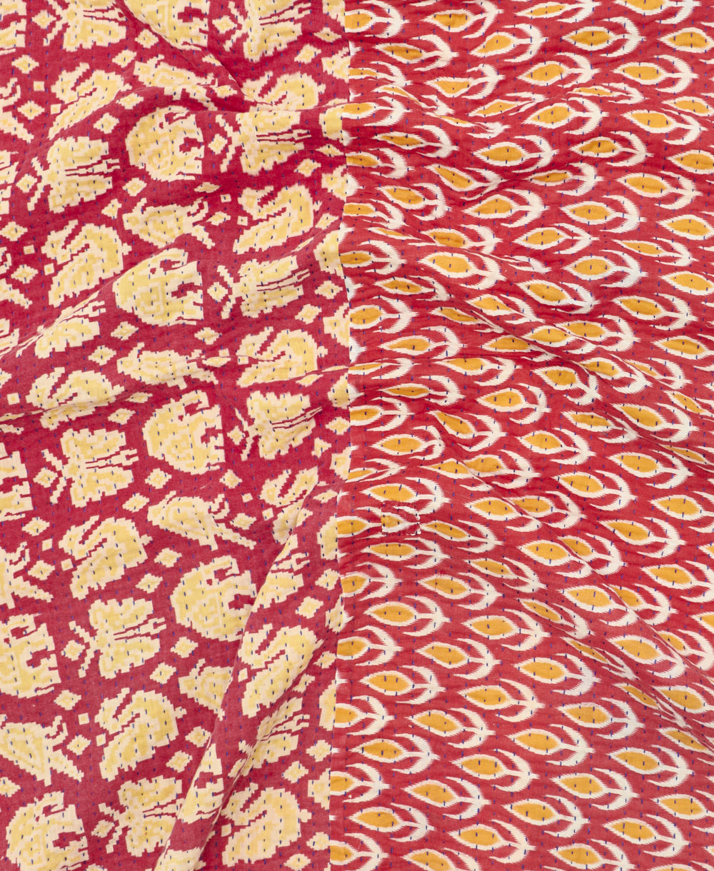 kantha quilt throw with a tag featuring the hand-stitched signature of the maker