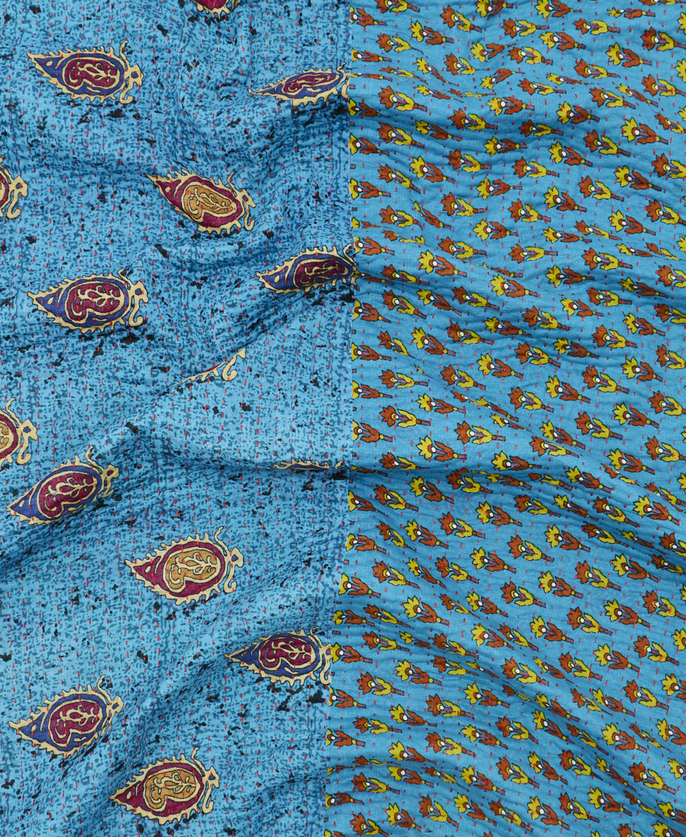 kantha quilt throw with a tag featuring the hand-stitched signature of the maker