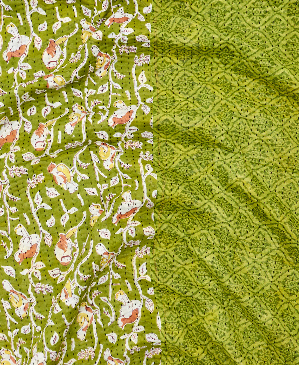 kantha quilt throw with a tag featuring the hand-stitched signature of the maker