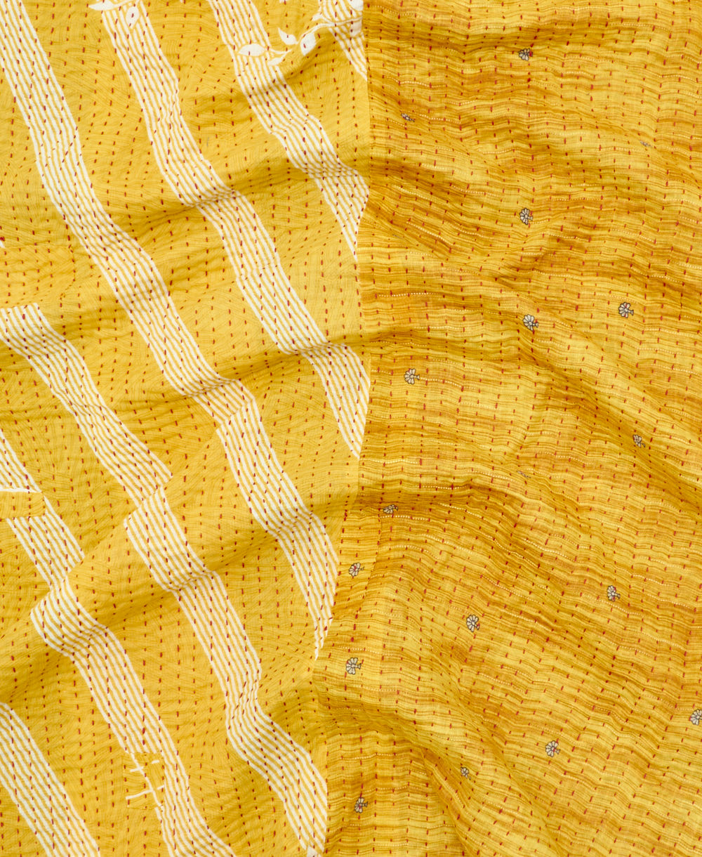 kantha quilt throw with a tag featuring the hand-stitched signature of the maker