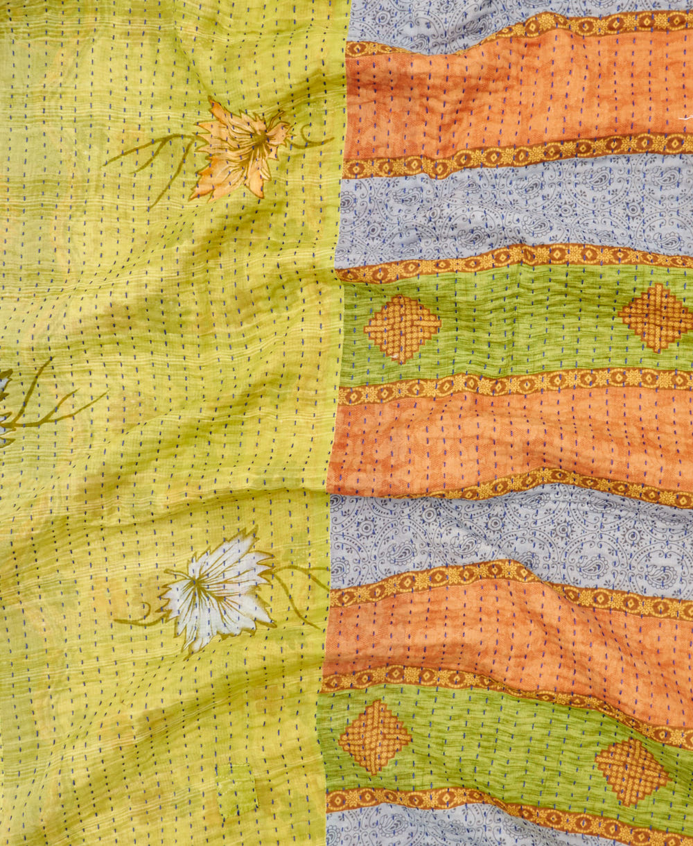 kantha quilt throw with a tag featuring the hand-stitched signature of the maker