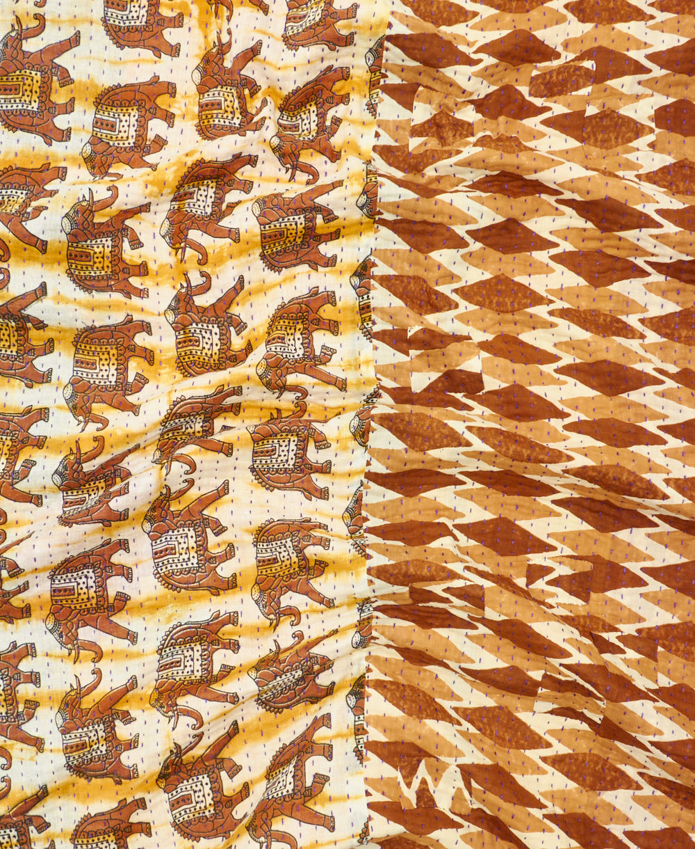 kantha quilt throw with a tag featuring the hand-stitched signature of the maker