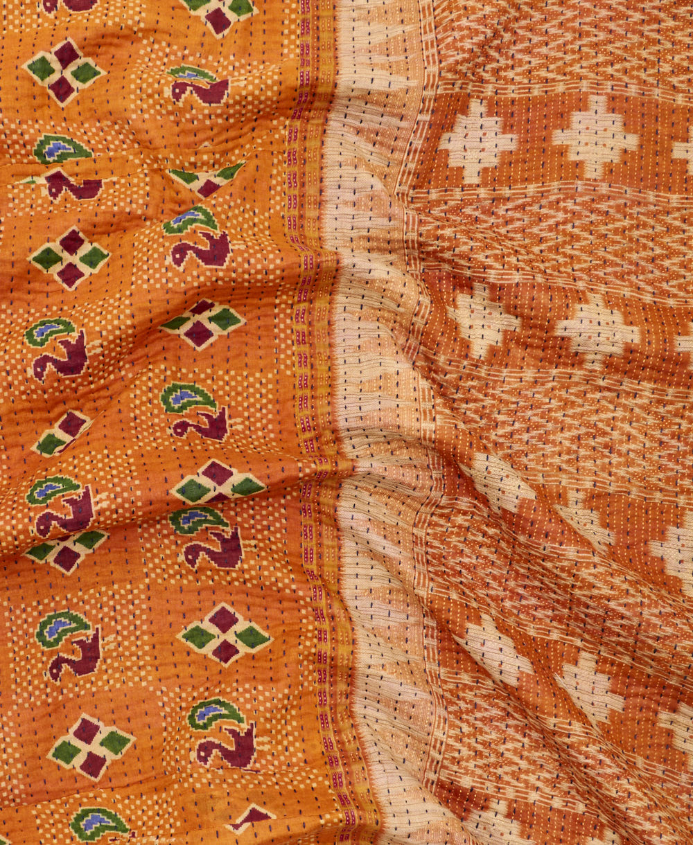 kantha quilt throw with a tag featuring the hand-stitched signature of the maker